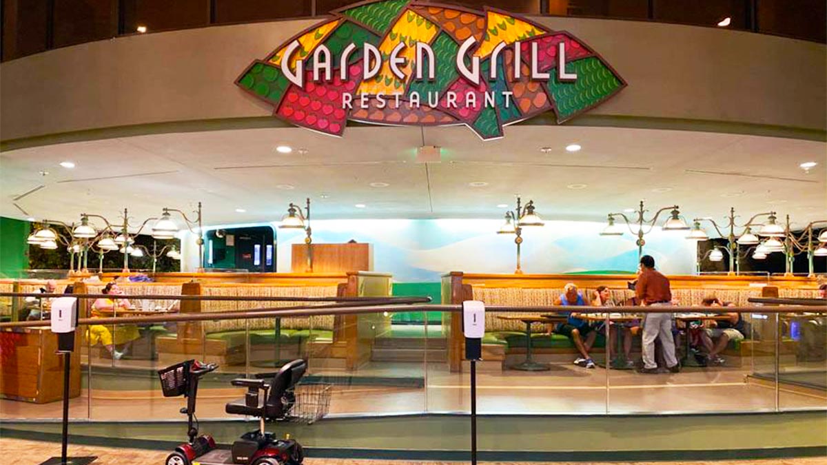 waiter attending to diners seated at booth at Garden Grill Restaurant in Epcot in Orlando, Florida, USA
